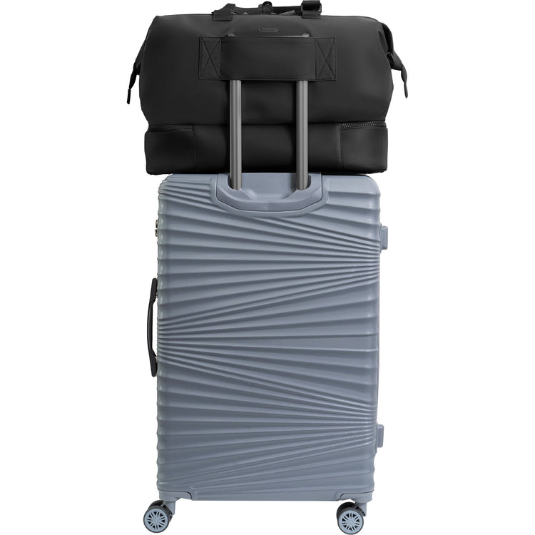 Gray suitcase with a black duffel bag on top against a white background