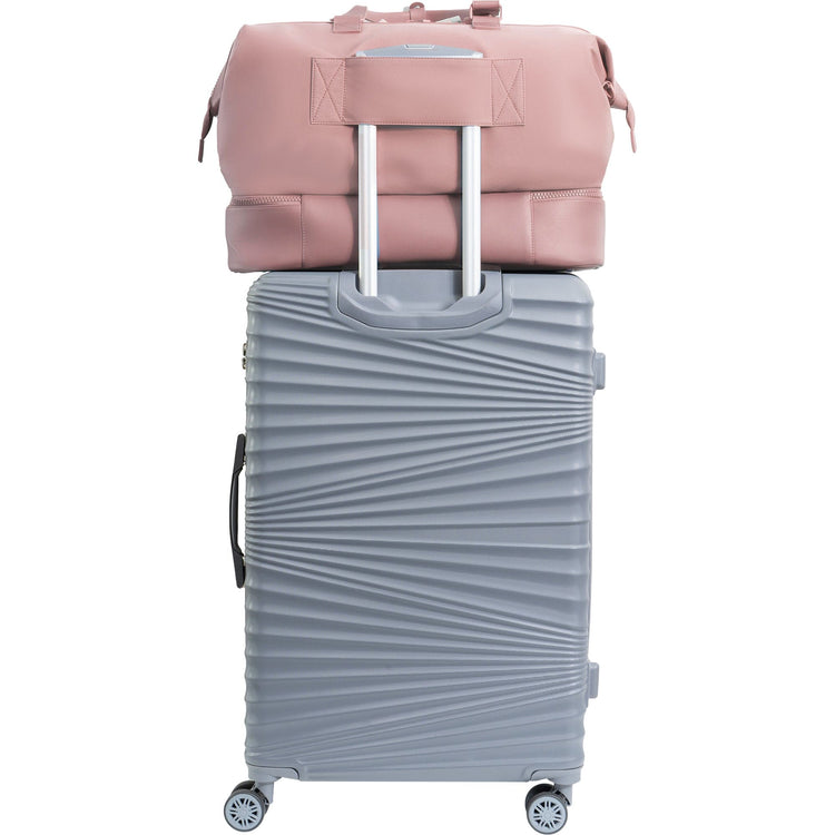 Gray suitcase with a pink backpack on top against a white background