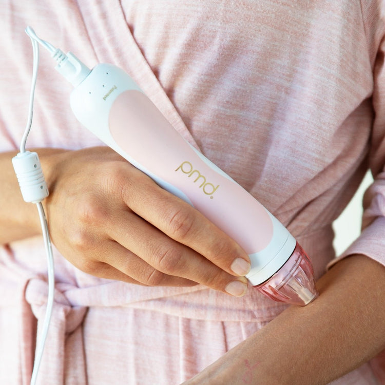 Person using a pink and white pmd device on their arm