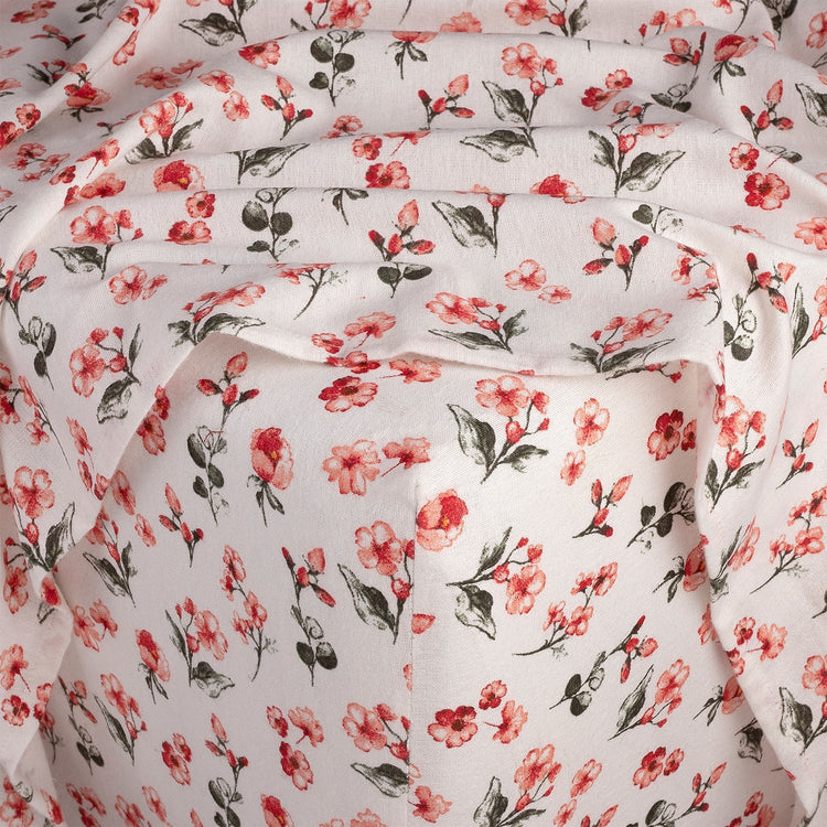 Floral patterned fabric with red flowers and green leaves on a white background
