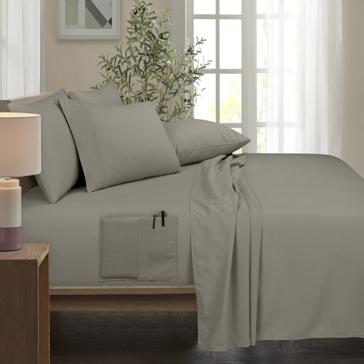 Beige bed sheets and pillows on a bed in a bedroom setting.