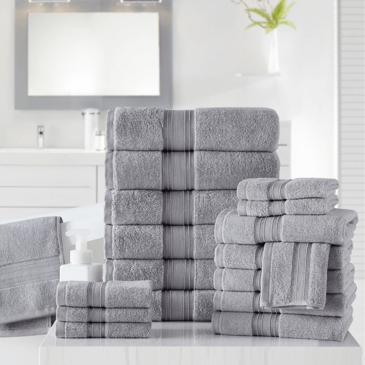 Stack of gray towels with striped patterns on a bathroom counter.