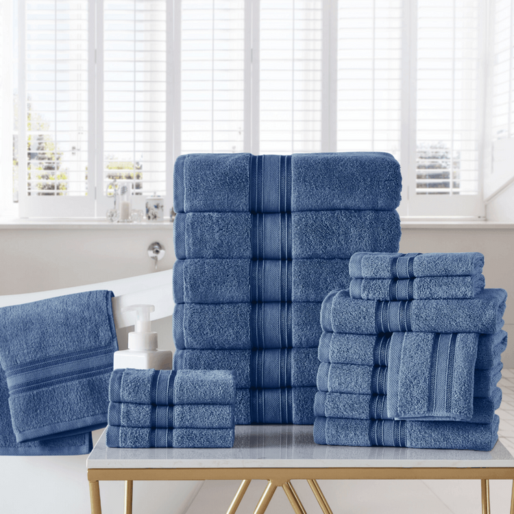 Set of blue towels stacked on a table with a window in the background