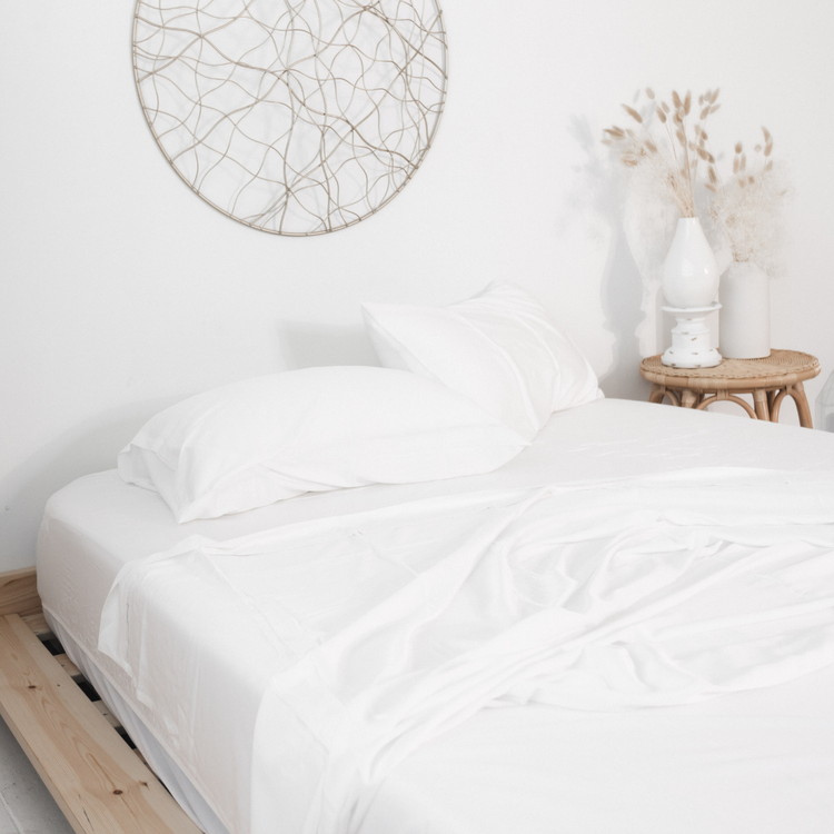 Bed with white bedding in a minimalistic bedroom setting