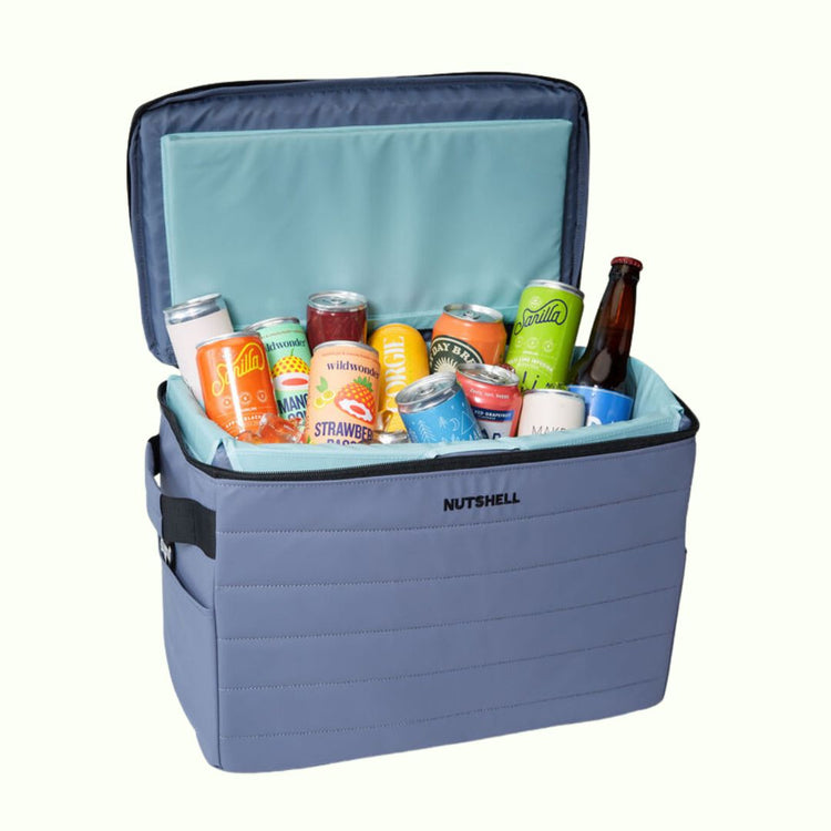 Blue Nutshell sustainable cooler bag with assorted drinks on a white background