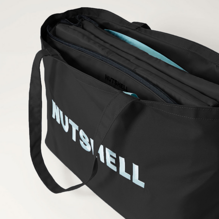 Black tote bag with 'NUTSHELL' embroidery on a light gray background