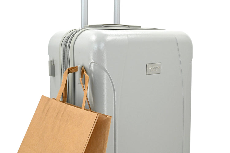 White suitcase with a brown paper bag attached on a white background