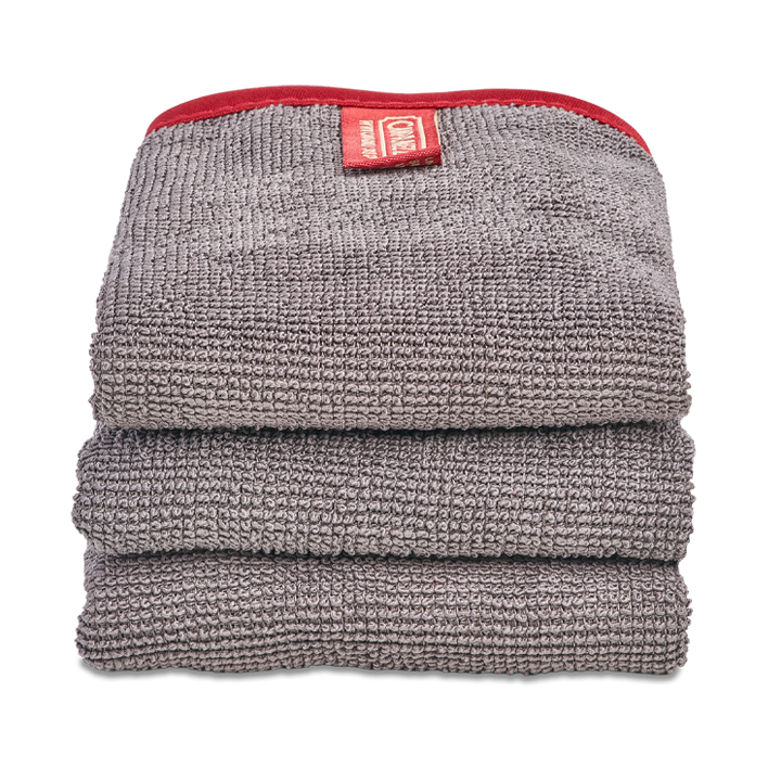 Stack of gray towels with a red label on a white background