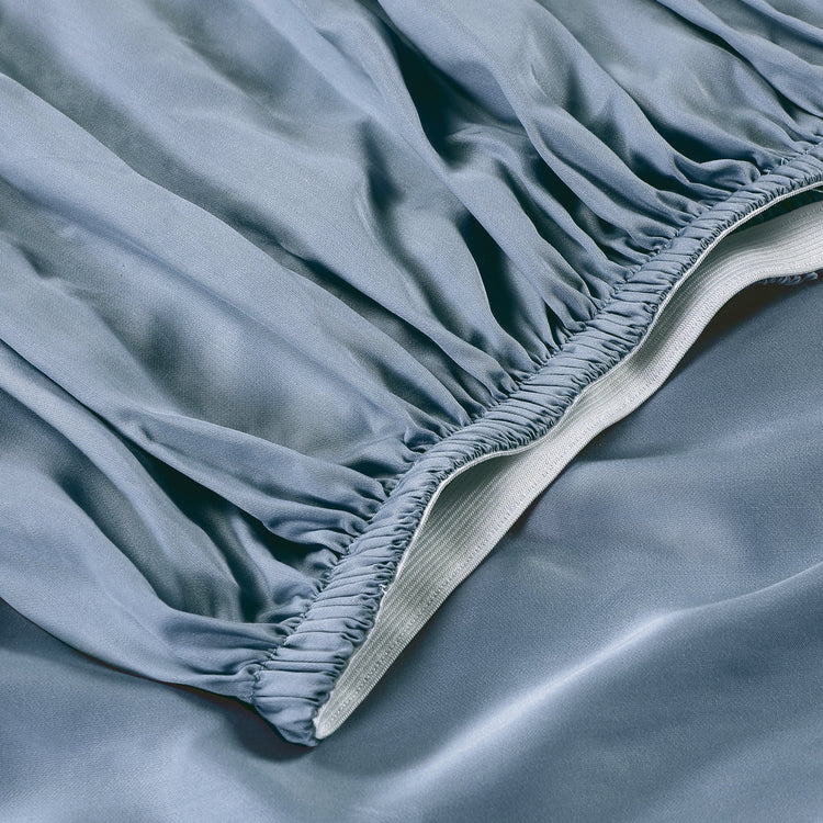 Close-up of a fitted sheet on a bed with a soft texture.