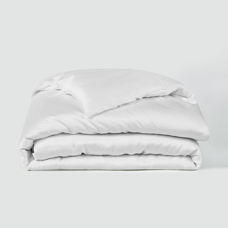 Stack of white bedding on a light gray background