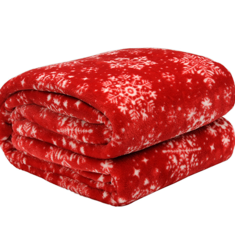 Folded red blanket with white snowflake pattern on a white background