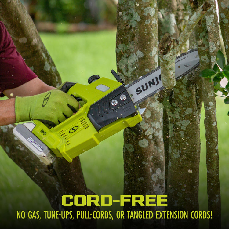 Person using a Sun Joe cordless chainsaw to trim a tree branch with a blurred green background.