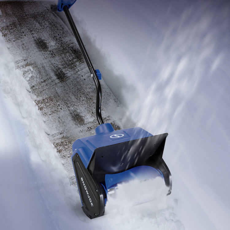 Blue snow shovel being used to clear snow from a driveway