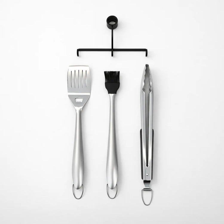 Set of three metal barbecue tools on a white background