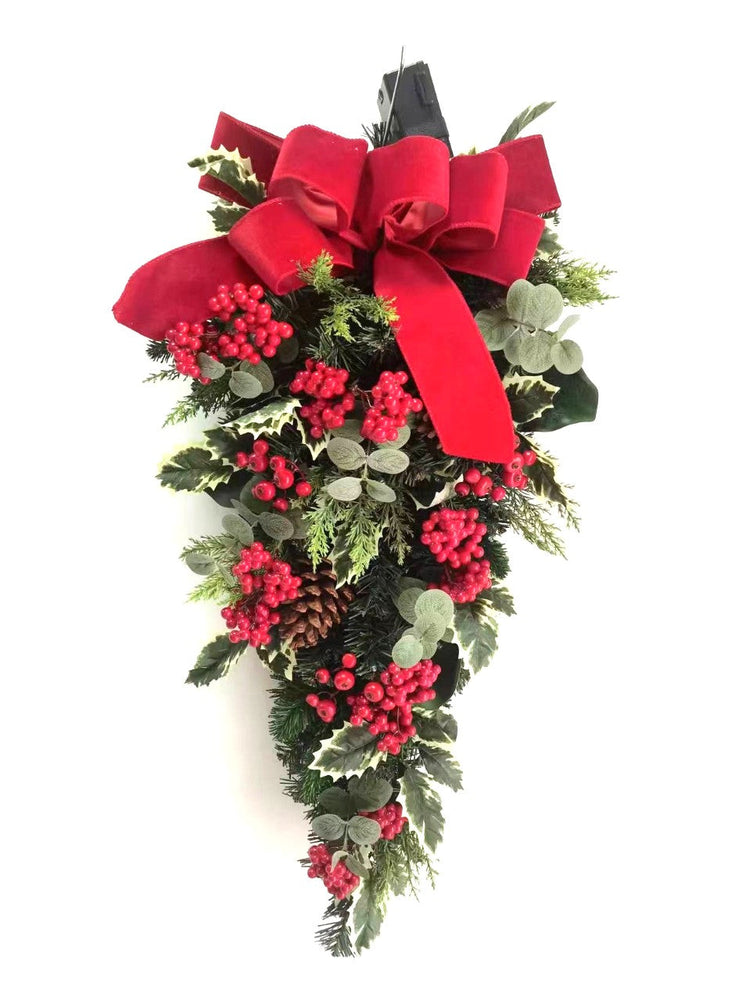 Christmas wreath with red berries, greenery, and a large red bow on a white background