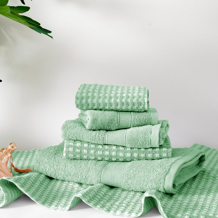 Stack of green towels on a white background