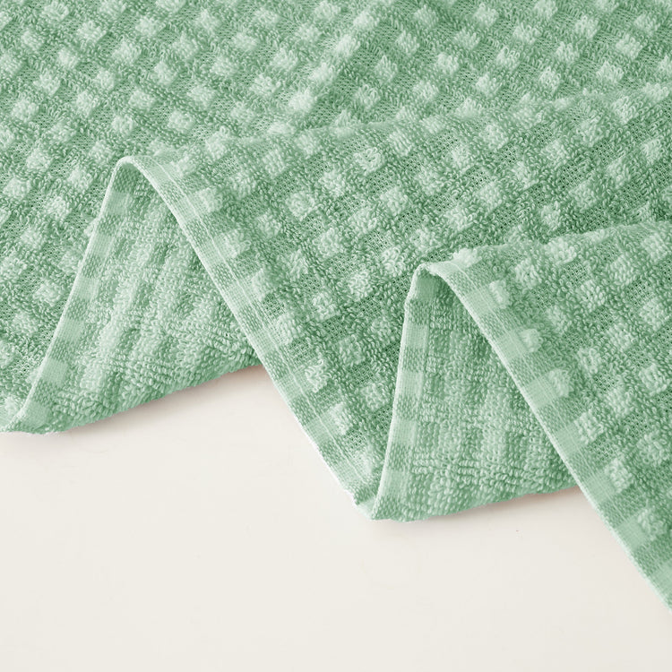 Green checkered towel on a white background