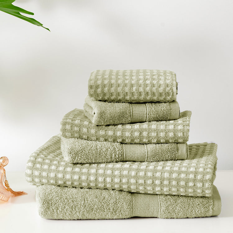Stack of green towels on a white background