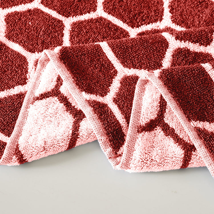 Red and white patterned rug on a light gray surface