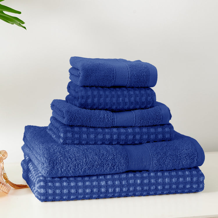 Stack of blue towels on a white surface with a light background