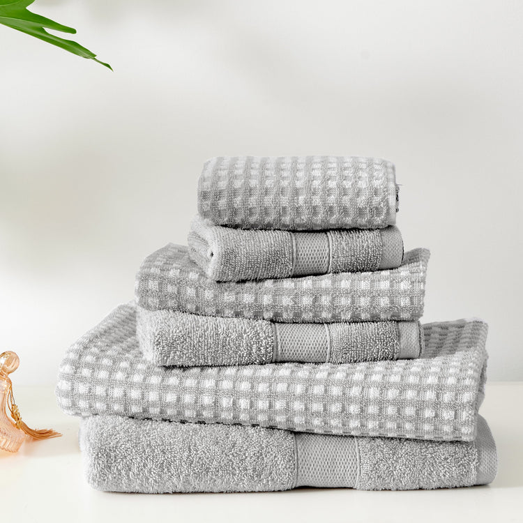 Stack of gray towels on a white surface with a minimal background