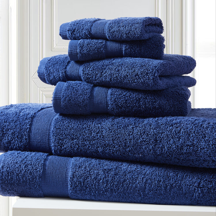 Stack of blue towels on a white surface with a white wall background