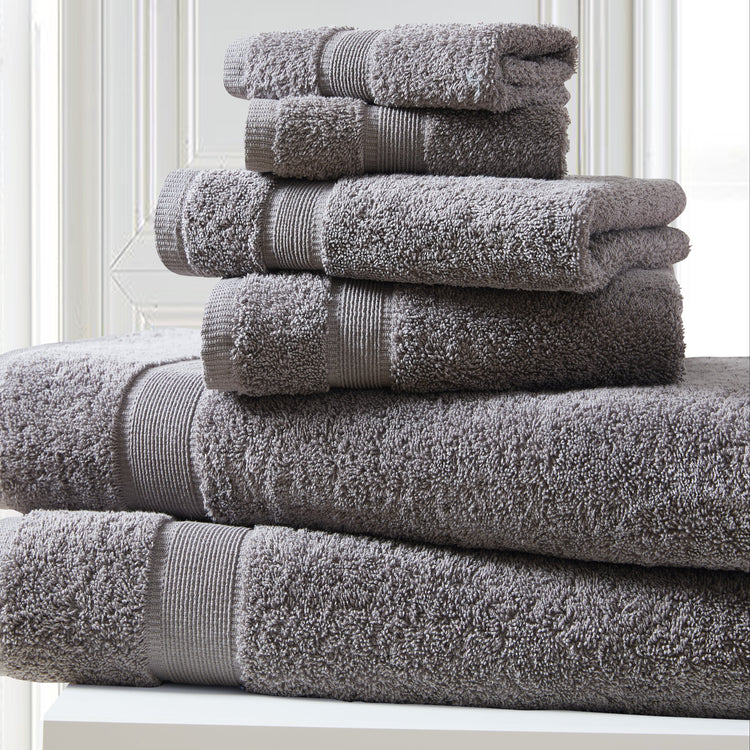 Stack of gray towels on a white surface with a light background