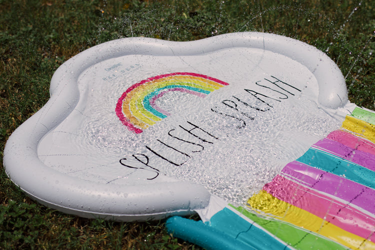 Inflatable pool with rainbow design and text on grass