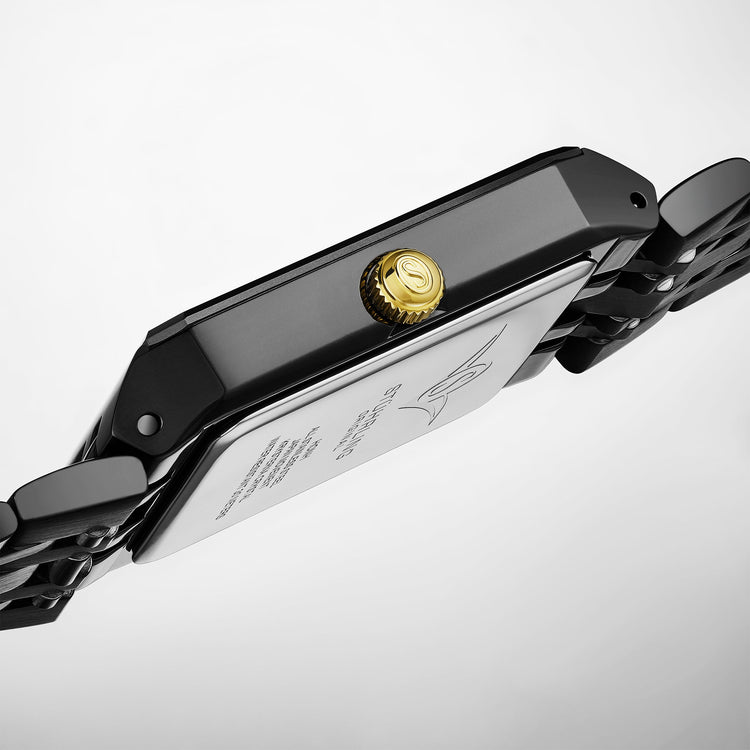 Close-up of a black watch band with a gold clasp on a light gray background