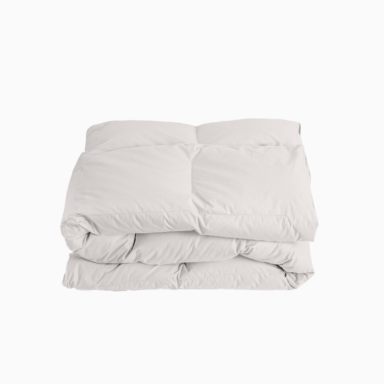 Folded light gray comforter on a white background
