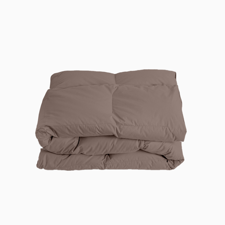 Folded brown comforter on a white background