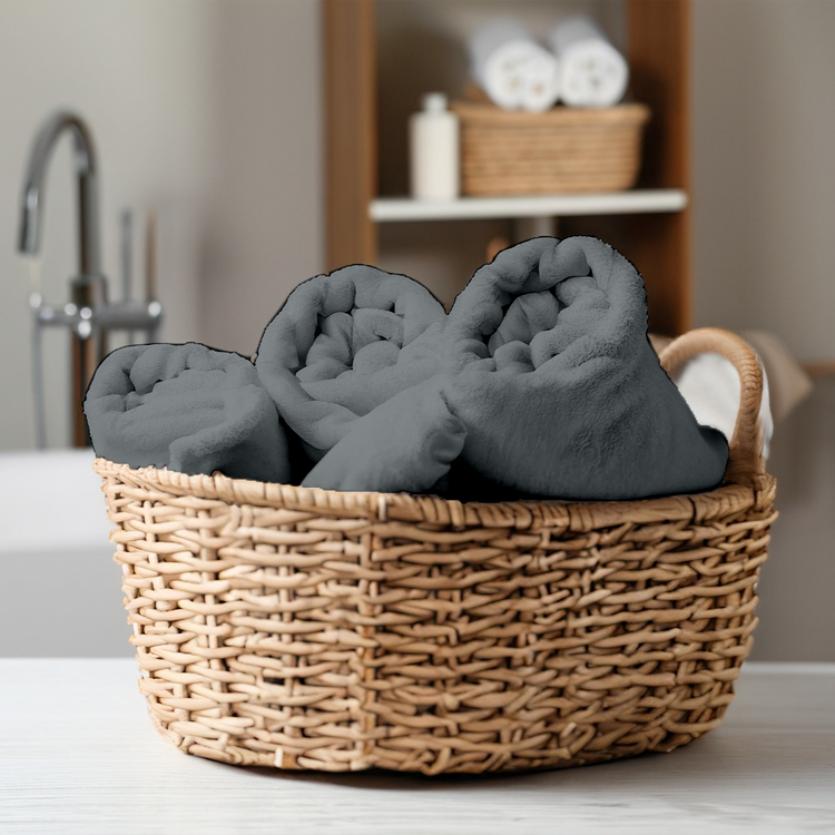 Wicker basket with gray towels on a bathroom counter