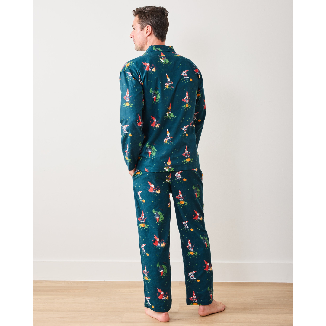 Person wearing a teal pajama set with colorful patterns on a white background