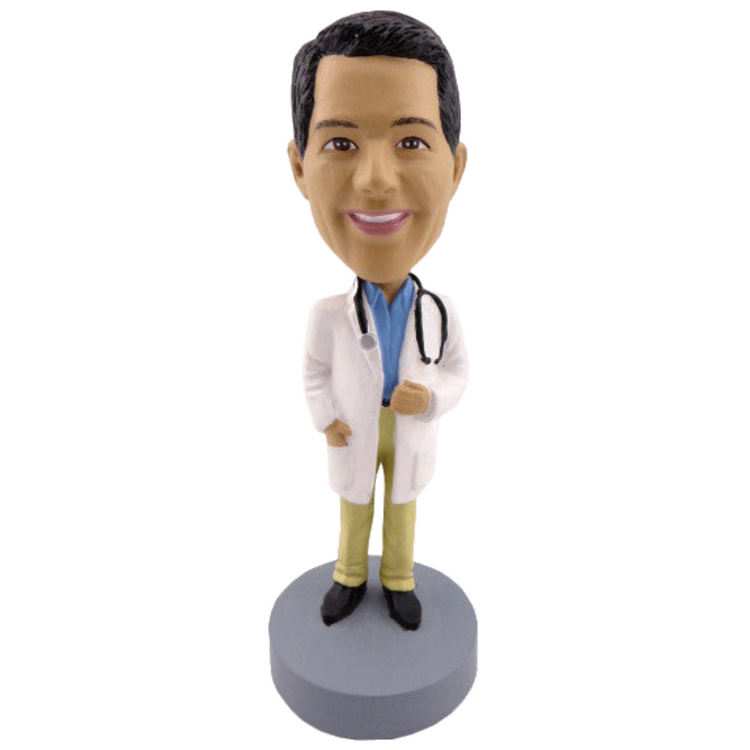 Bobblehead of a doctor in a white coat with a stethoscope on a gray base against a white background