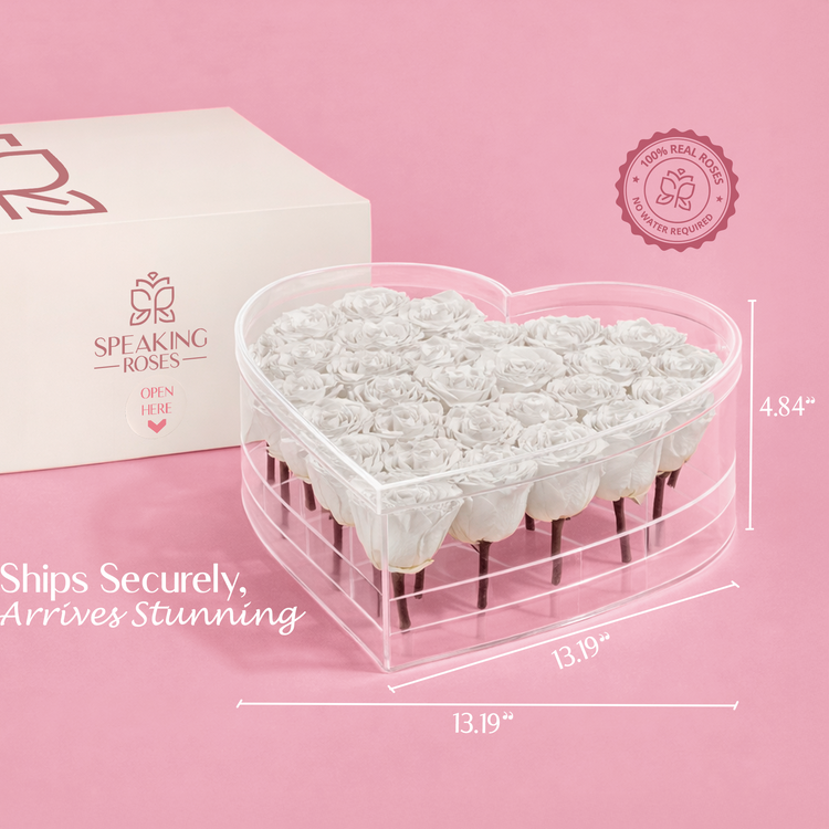 Heart-shaped container with white roses, branded box, and measurement details on a pink background