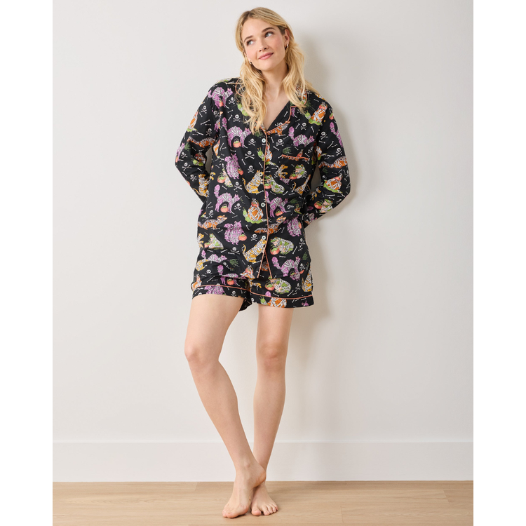 Woman wearing a floral pajama set against a plain background