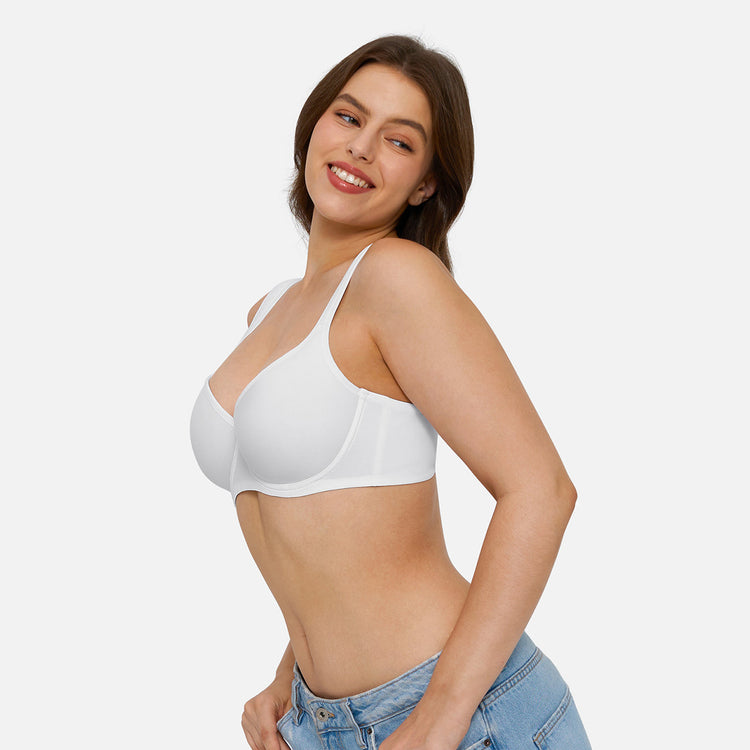 A woman wearing a white wireless underwire bra and light blue jeans, posing against a solid light gray background.