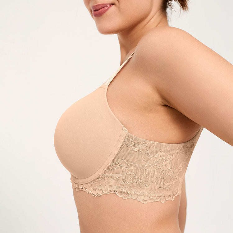 A close-up side view of a woman wearing a nude-beige underwire bra with a lace-trimmed band and smooth molded cup.