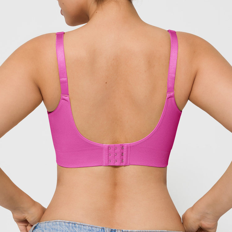 Person wearing a pink bra on a plain background