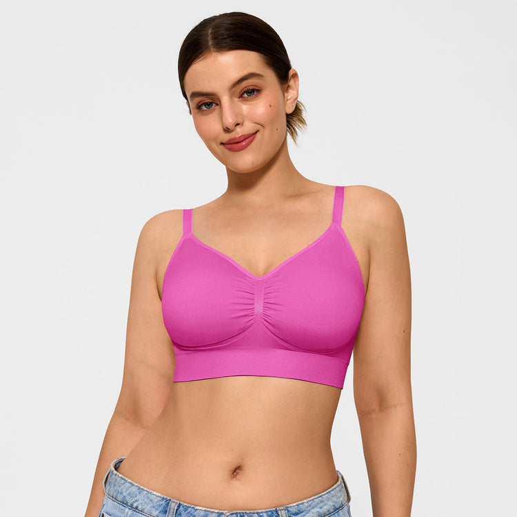 Woman wearing a pink bralette against a plain background