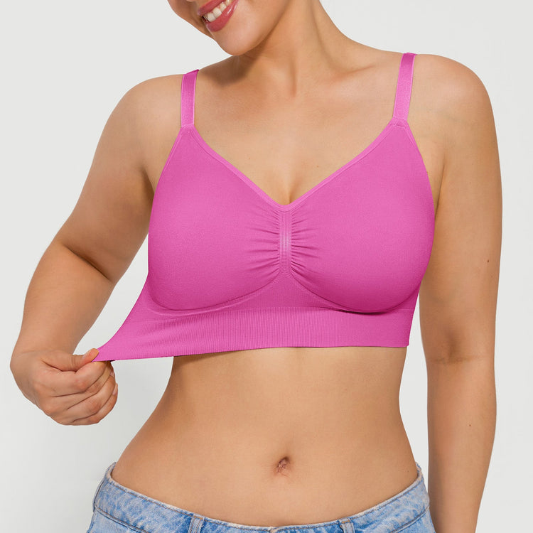 Woman wearing a pink bra against a plain background