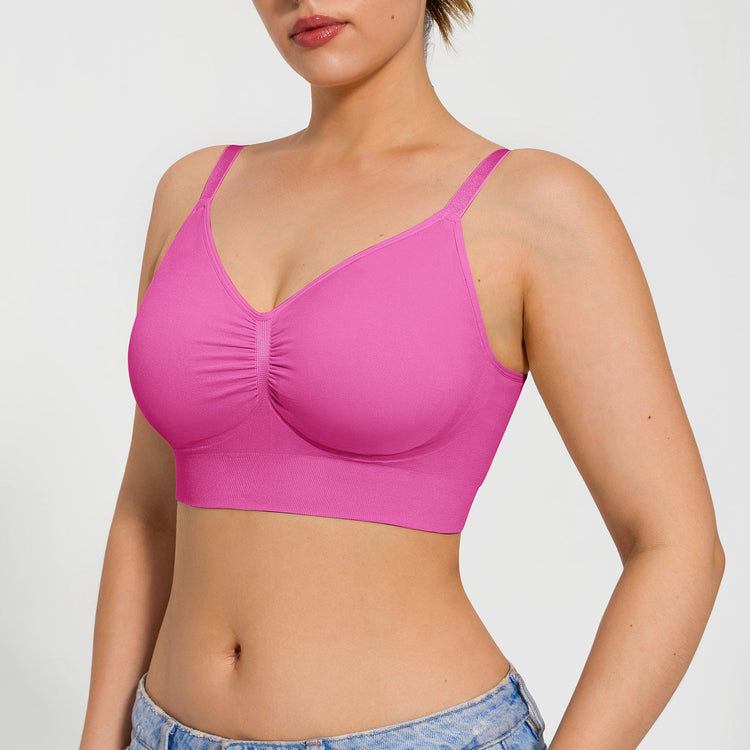 Woman wearing a pink sports bra on a plain background