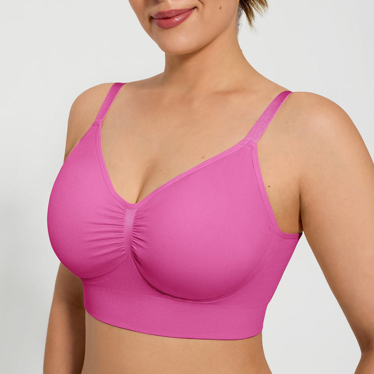 Woman wearing a pink bra against a plain background