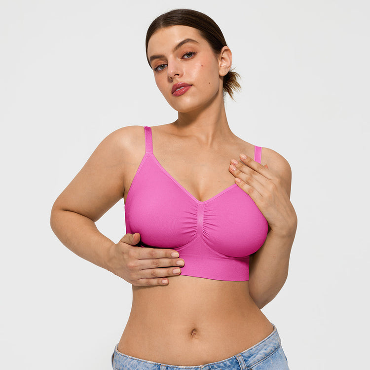 Woman wearing a pink bralette against a plain background