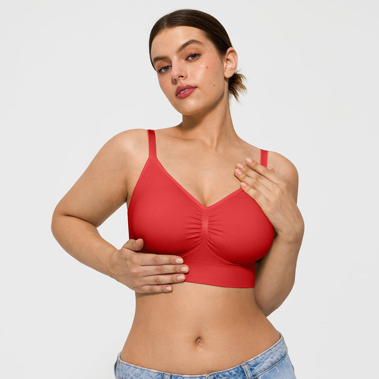 Woman wearing a red bralette against a plain background