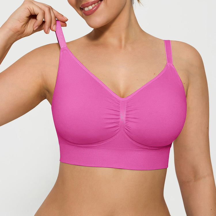Woman wearing a pink bra against a plain background