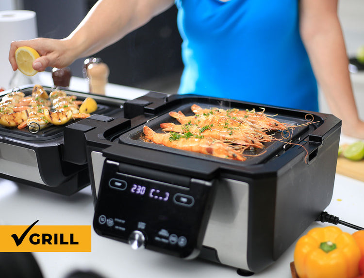 Electric grills with food being cooked, person in blue shirt in the background
