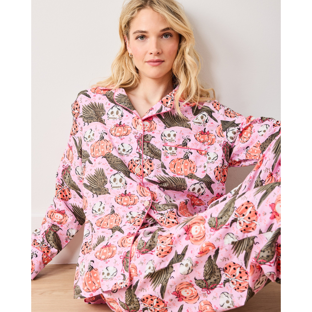 Woman wearing a pink floral patterned shirt with a neutral background