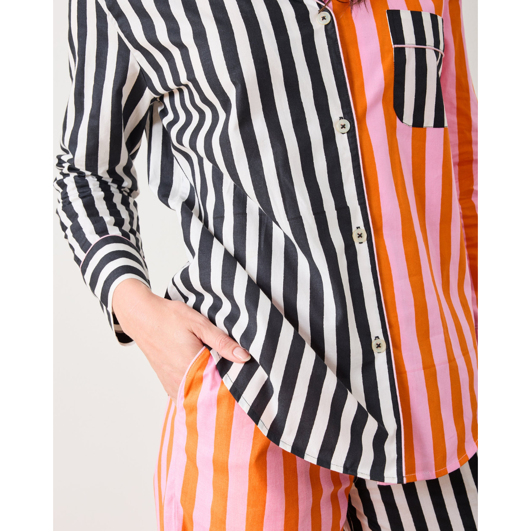 Colorful striped shirt with a mix of black, white, orange, and pink on a white background