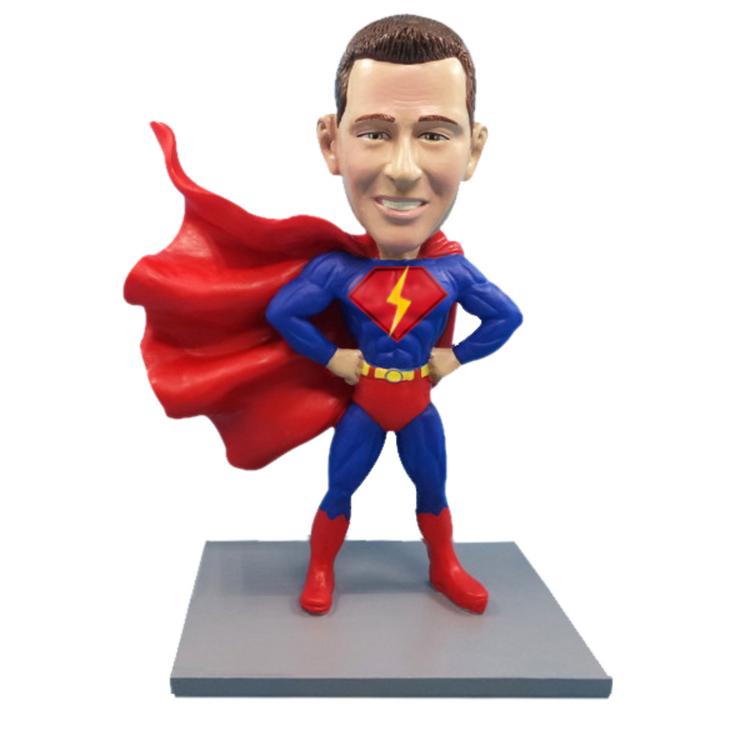 Superhero figurine with red cape and blue suit on a white background